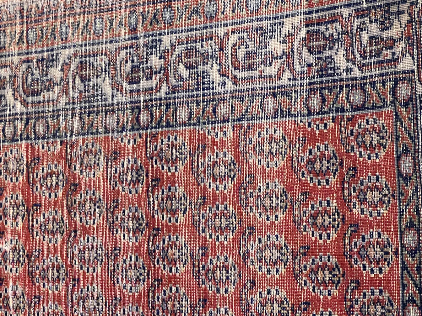 antique carpet with floral pattern in red and blue tones