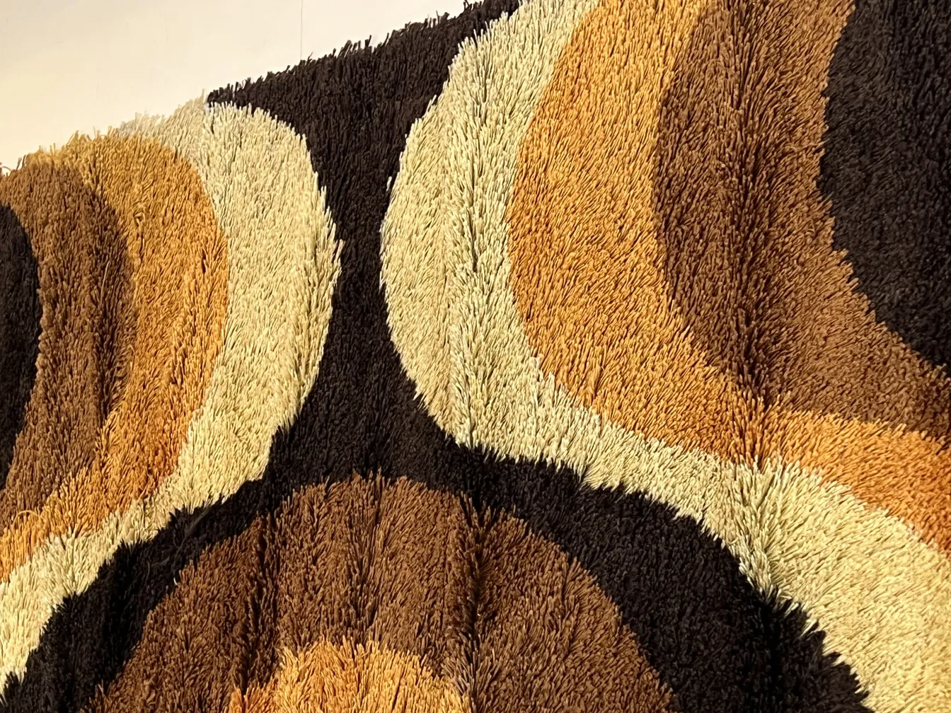 Tappeto antico con motivi geometrici nei toni di marrone e beige.