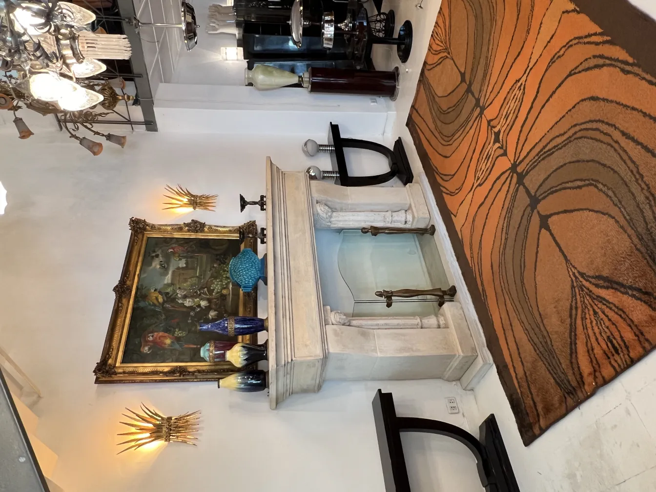 Антикварный коврик оранжевого и коричневого цветов в оформленном помещении.