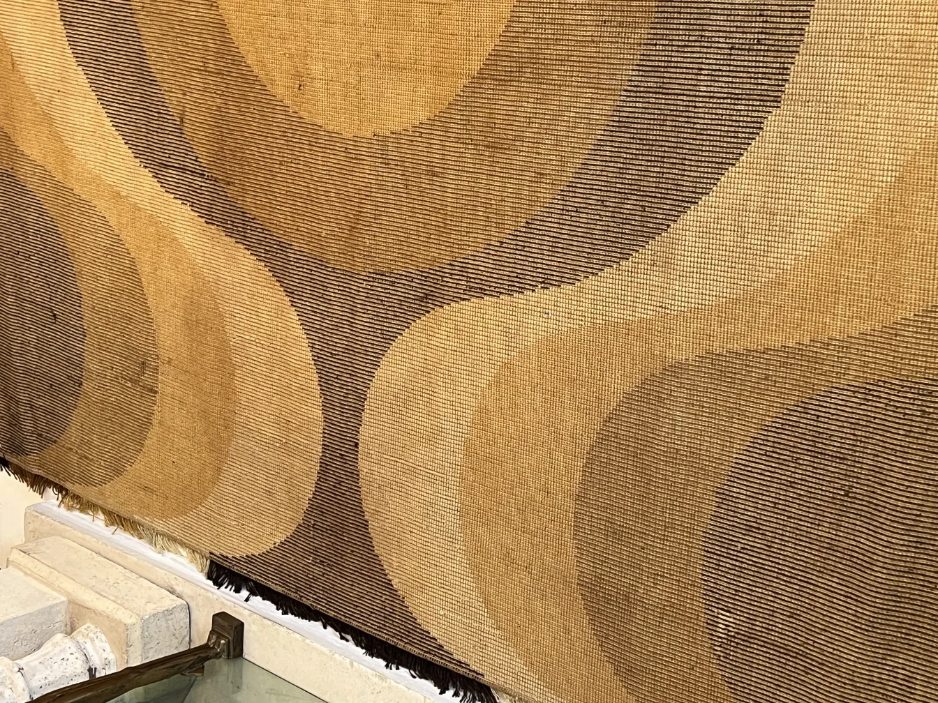 antique carpet featuring geometric patterns in brown and beige