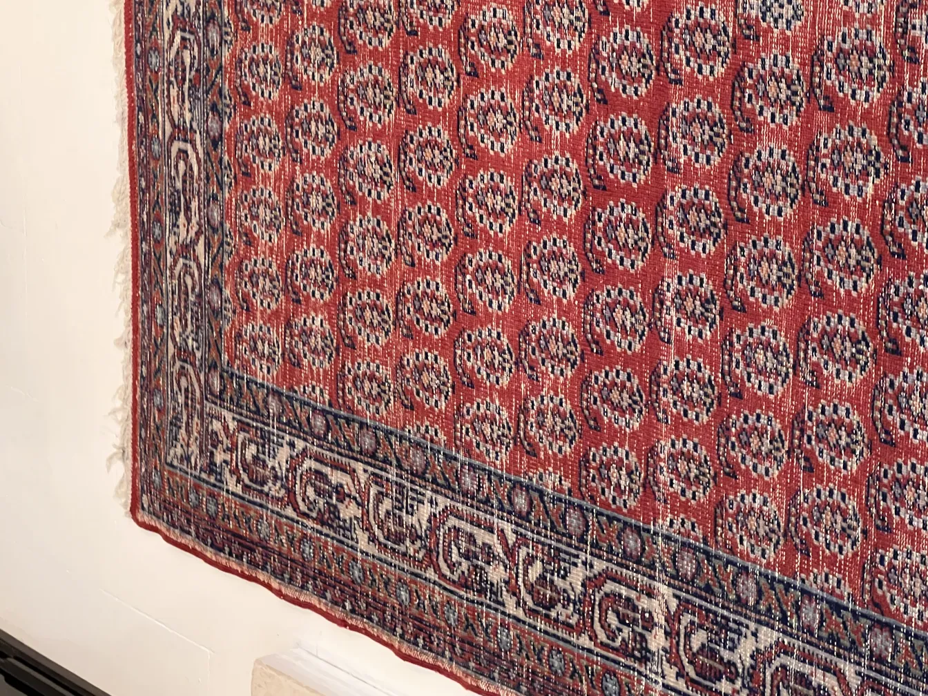 Antique red carpet with decorative pattern, classic setting.