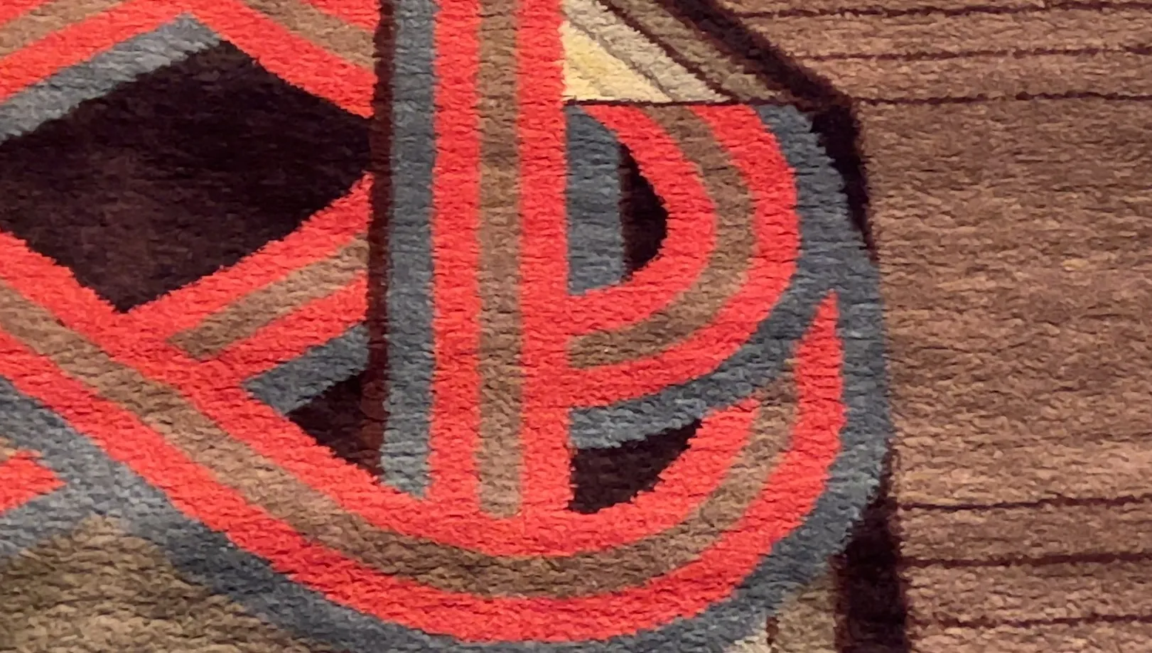 tapis ancien avec des motifs colorés en rouge et gris