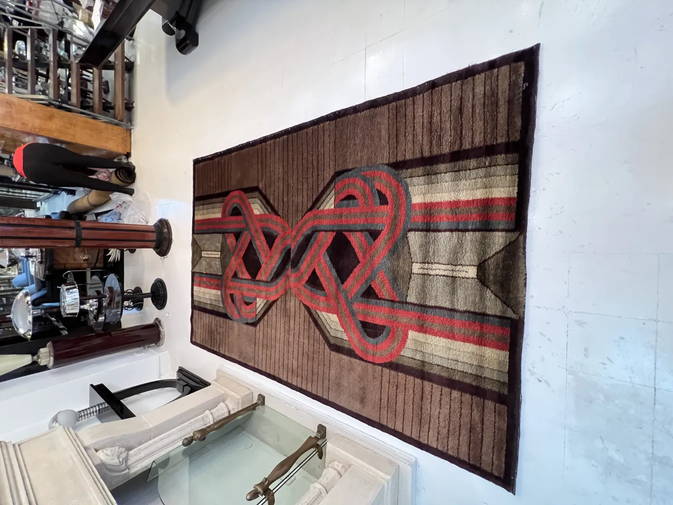 Antique carpet featuring geometric patterns in brown and red tones, enhancing an elegant and classic setting.