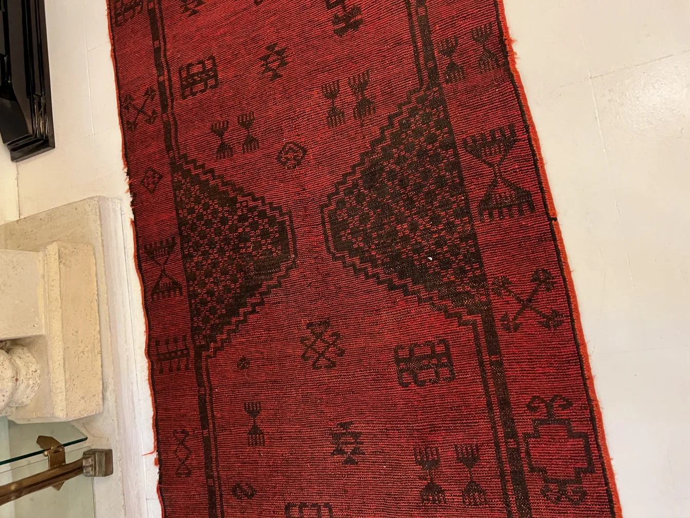 antiker roter Teppich mit verschiedenen Mustern in einer minimalistischen Umgebung