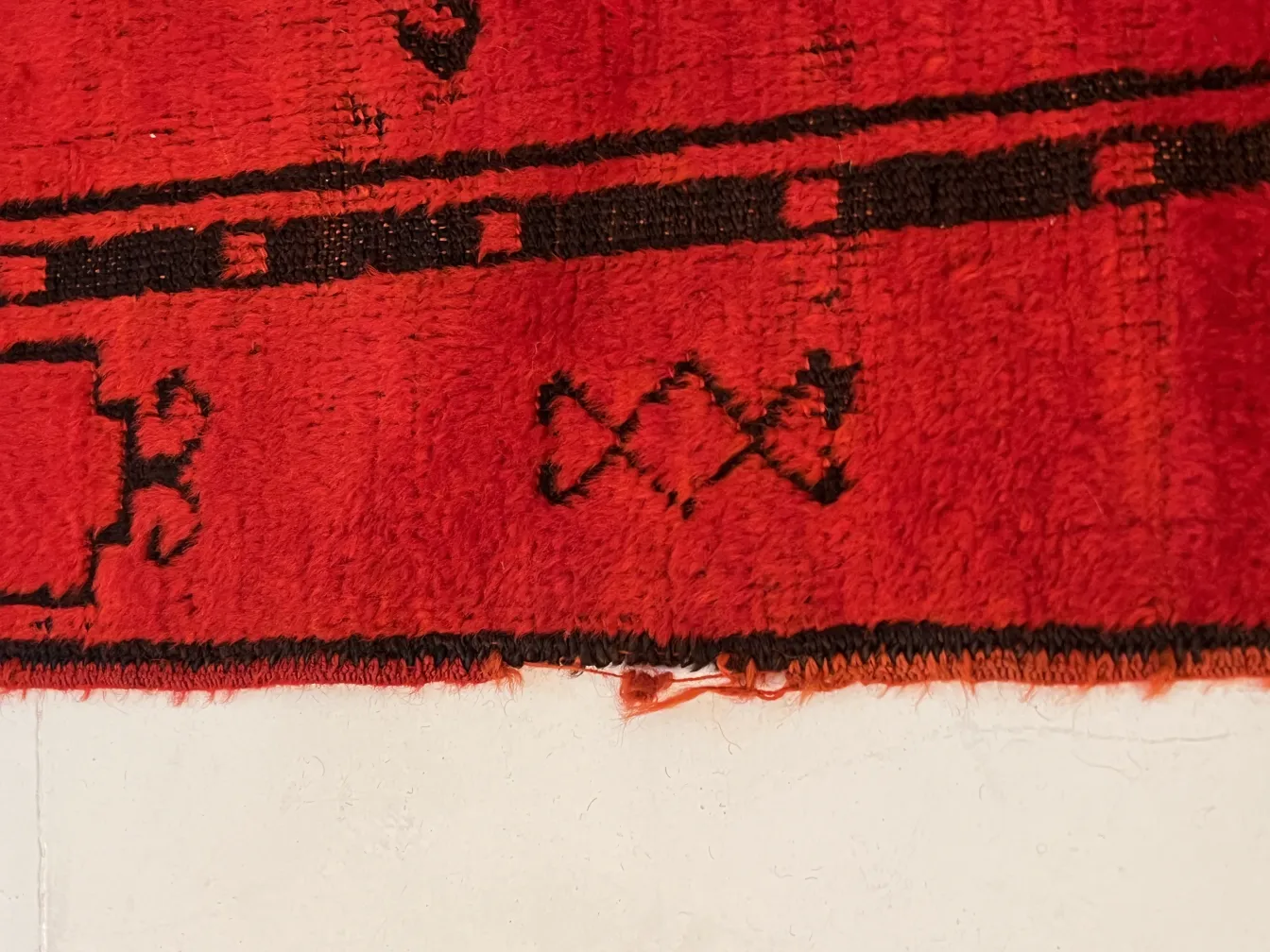close-up of an antique red carpet with distinctive patterns