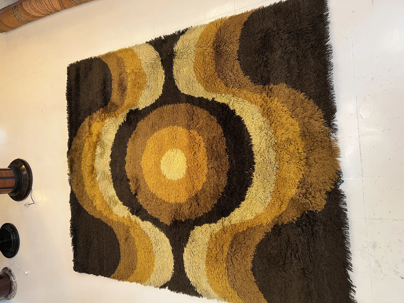 antique carpet with circular patterns in brown and yellow tones