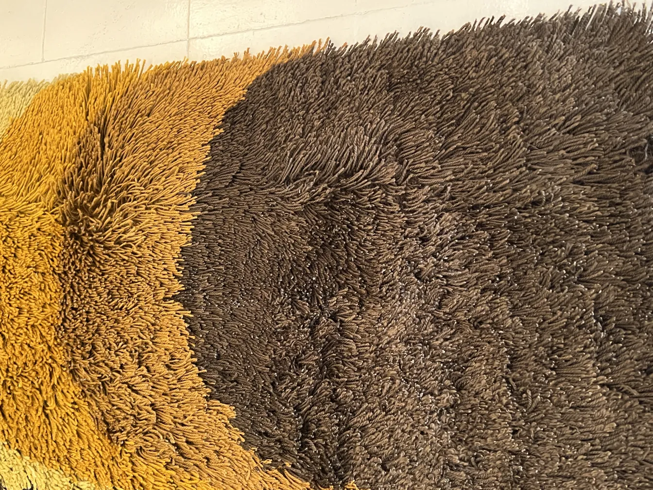 Antique carpet with warm textured colors in a cozy setting.