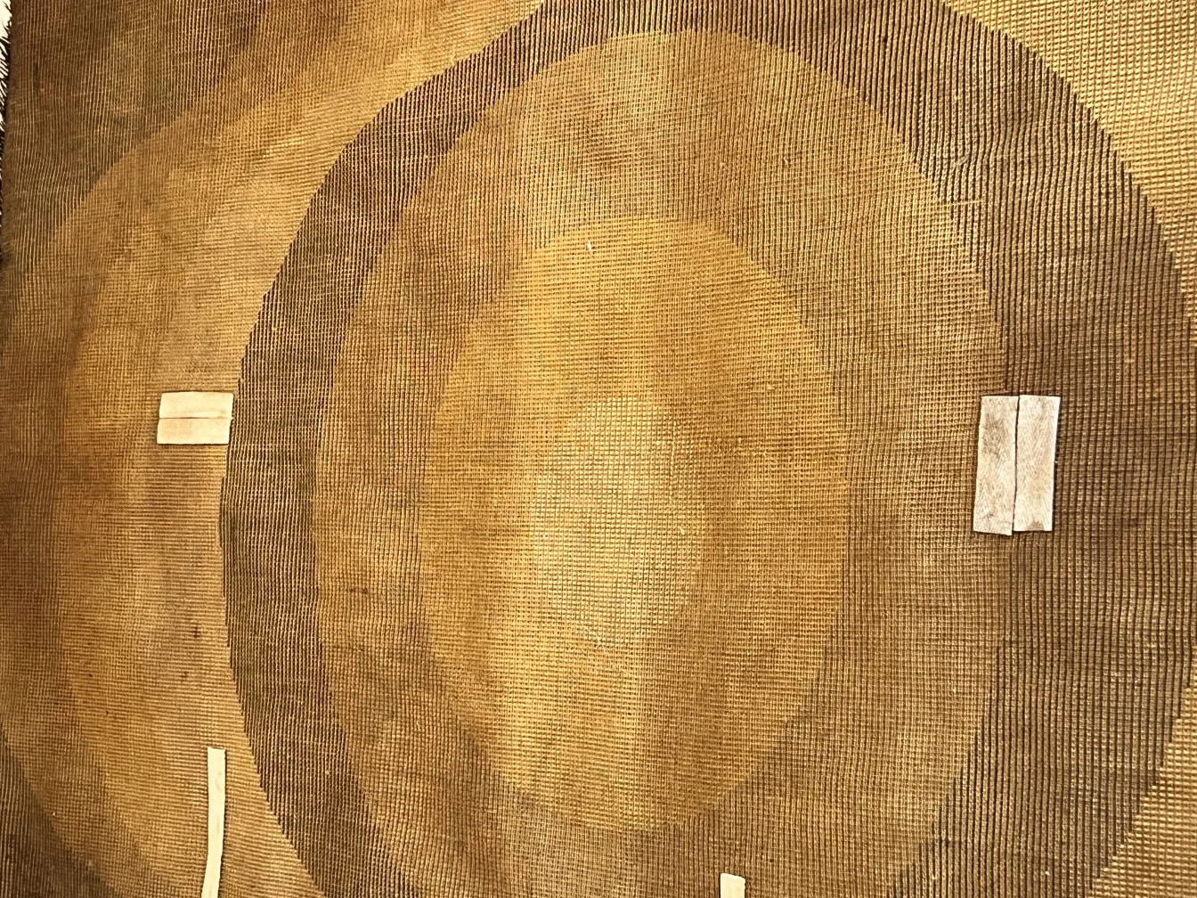antique carpet with circular design, light brown background
