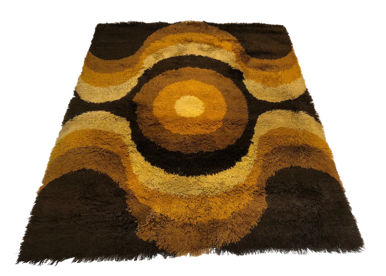 tapis ancien avec un design ondulé en couleurs brunes et dorées