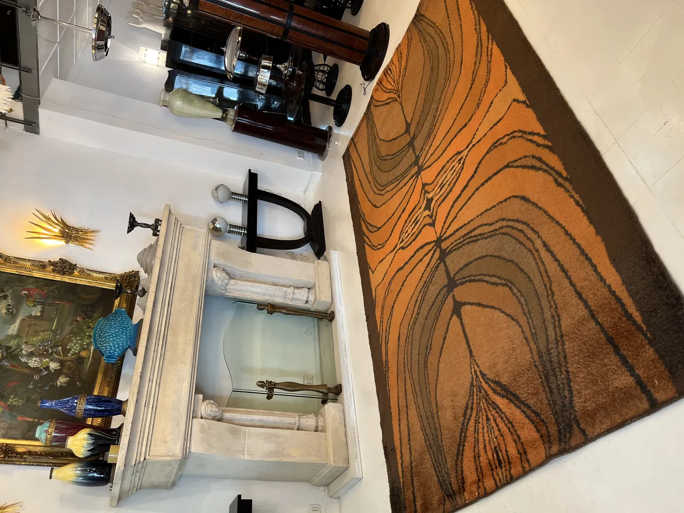 Tapis ancien avec motifs orange et marron, dans une pièce moderne.