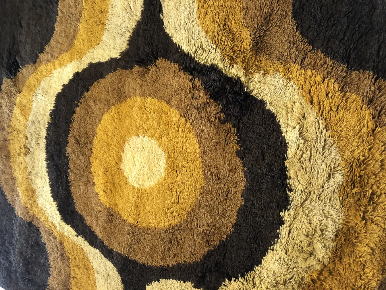 alfombra antigua con diseño en tonos marrones y amarillos