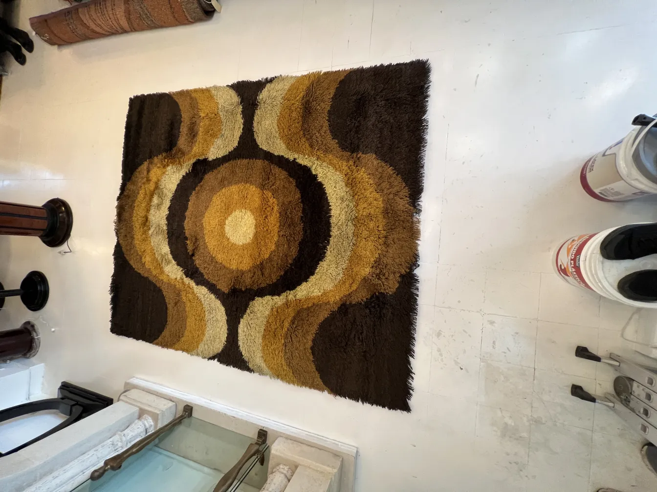 antique carpet featuring circular designs in brown and gold tones
