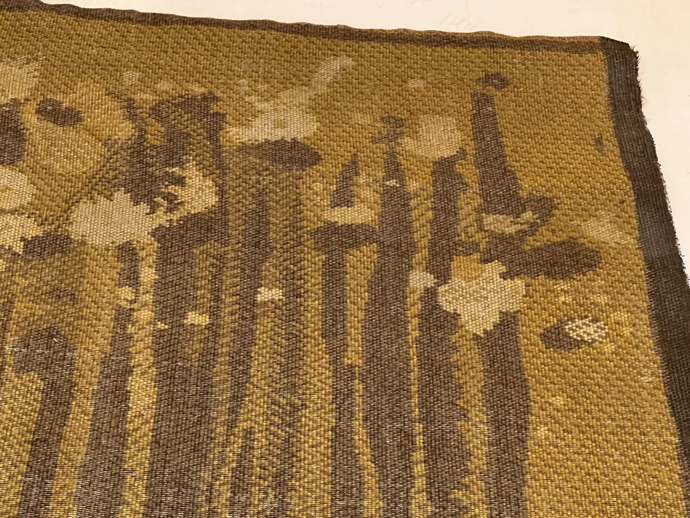 antiker teppich mit buntem muster in erdigen tönen