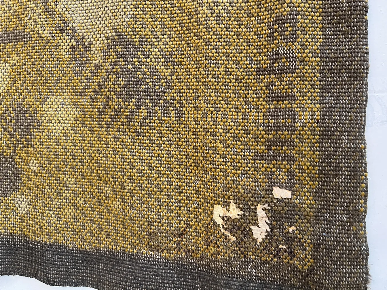 tapis ancien avec des couleurs terreuses et des détails usés