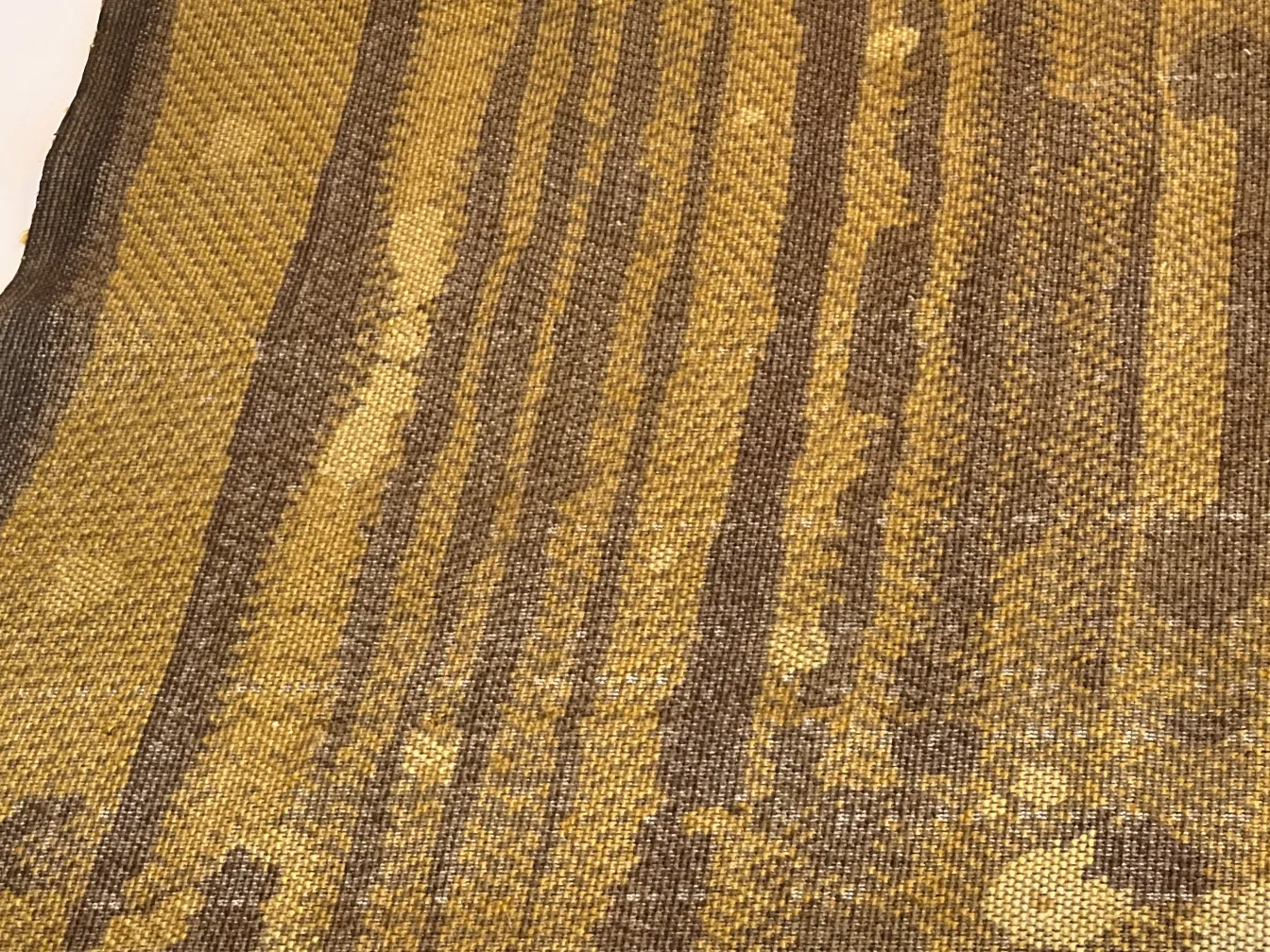 antique carpet with brown and yellow shades, varied textures