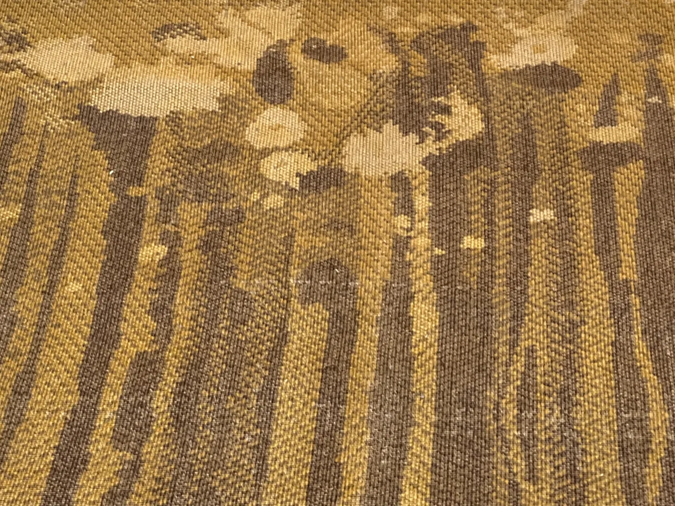 tapis ancien aux tons bruns et jaunes avec un motif distinctif