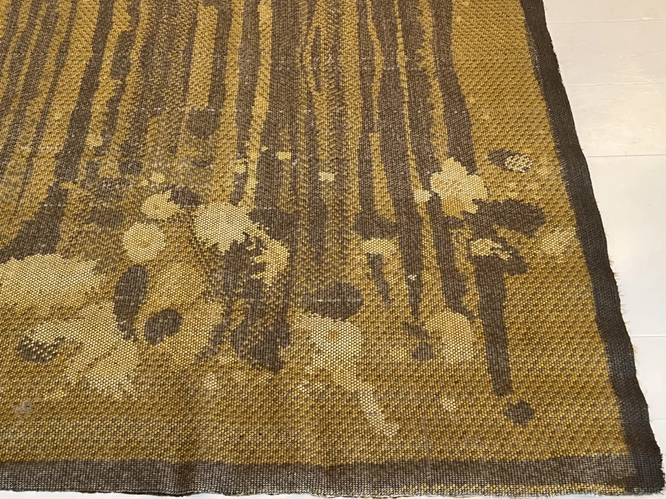 alfombra antigua con diseño de naturaleza en tonos marrones
