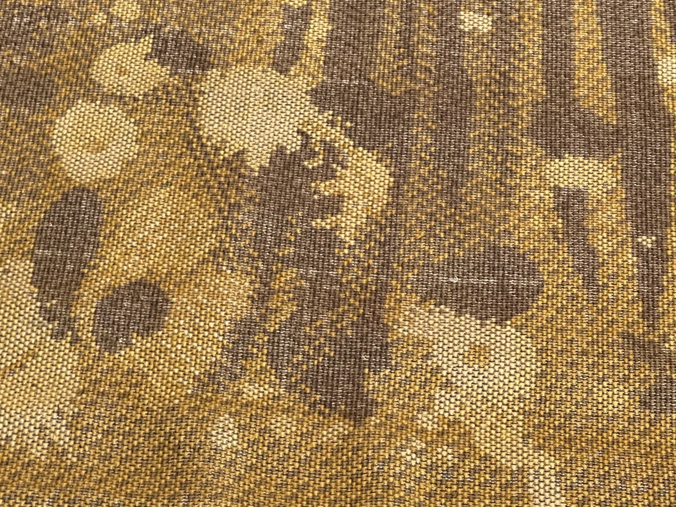 Tapis ancien avec design unique en tons de brun et doré, ambiance chaleureuse.