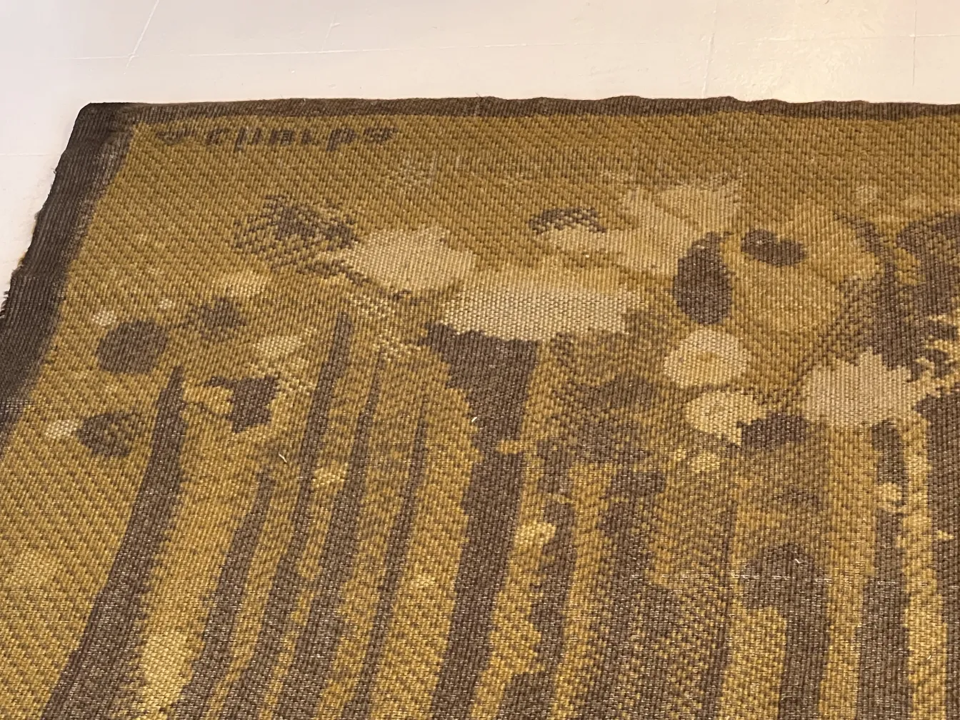 Tapis ancien avec un design de fleurs jaunes et brunes.