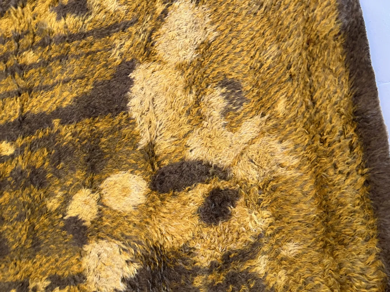tapis ancien avec des tons jaunes et marron, texture douce