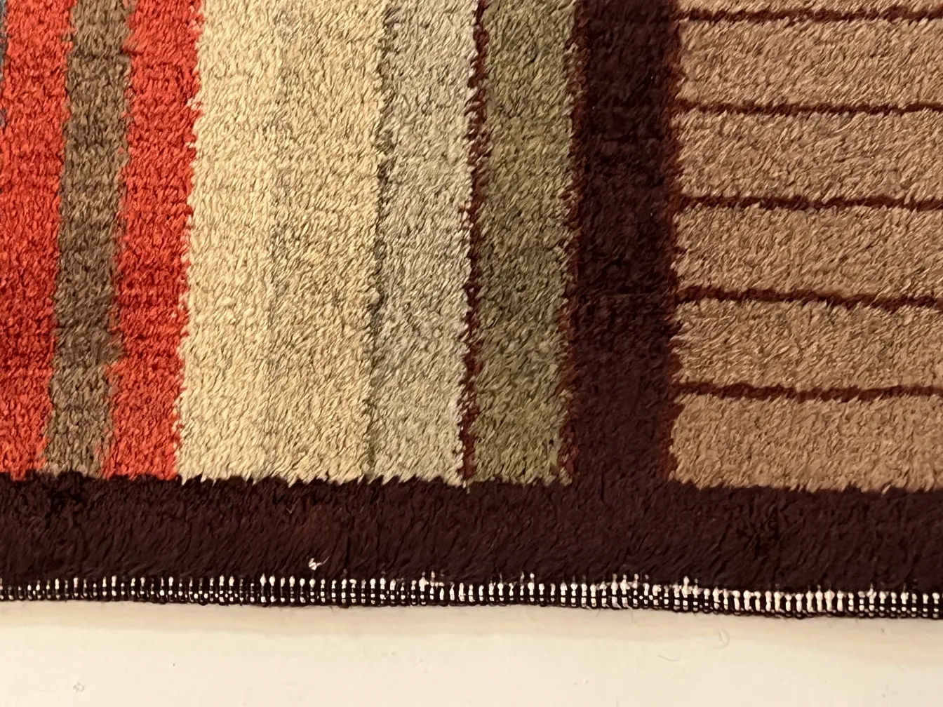 Antique carpet with warm and cool colored stripes.