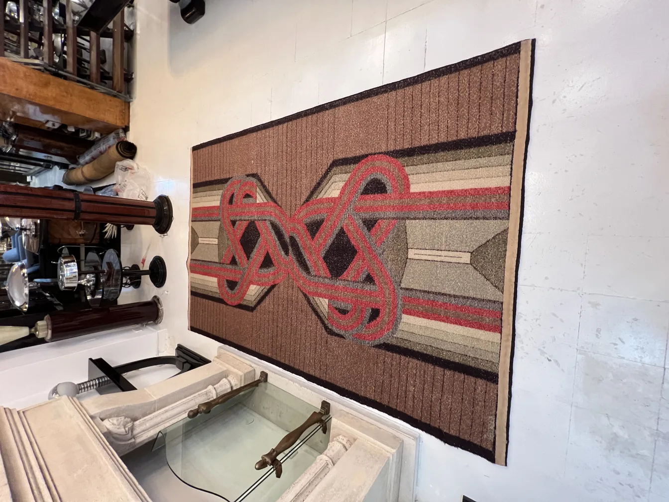 antique carpet with geometric design in brown and red tones