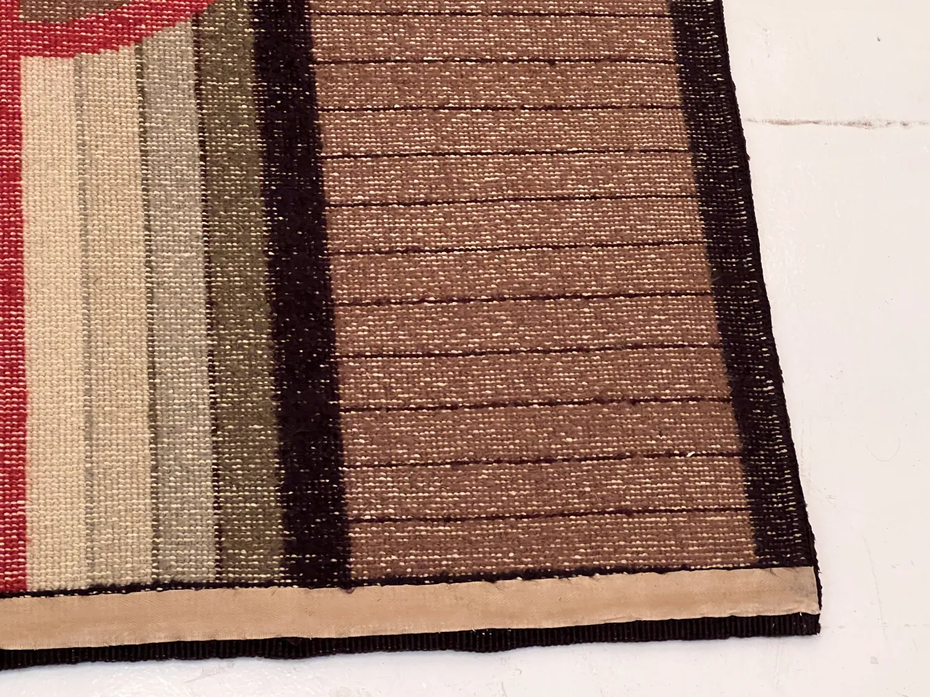 antique carpet with red, beige, and brown colors