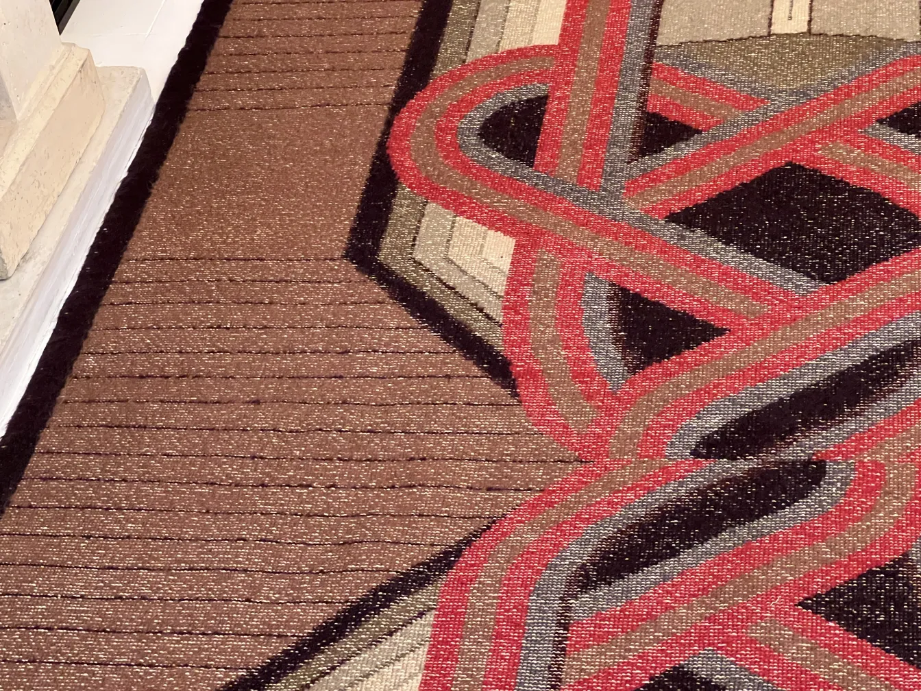 alfombra antigua con diseño en tonos marrones y rojo