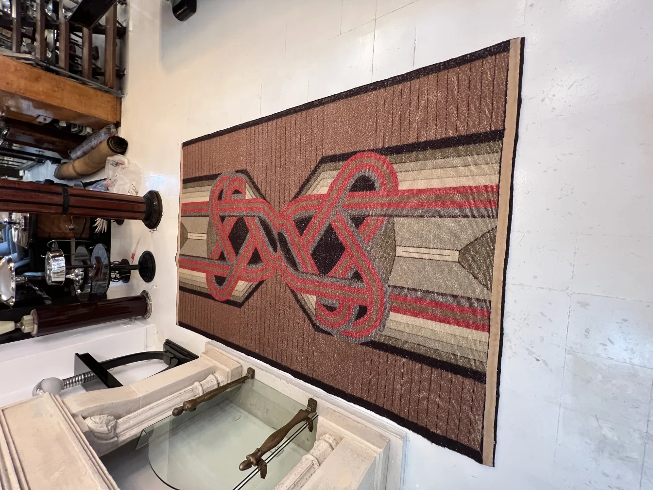 Antique carpet featuring brown and red color patterns and geometric design.