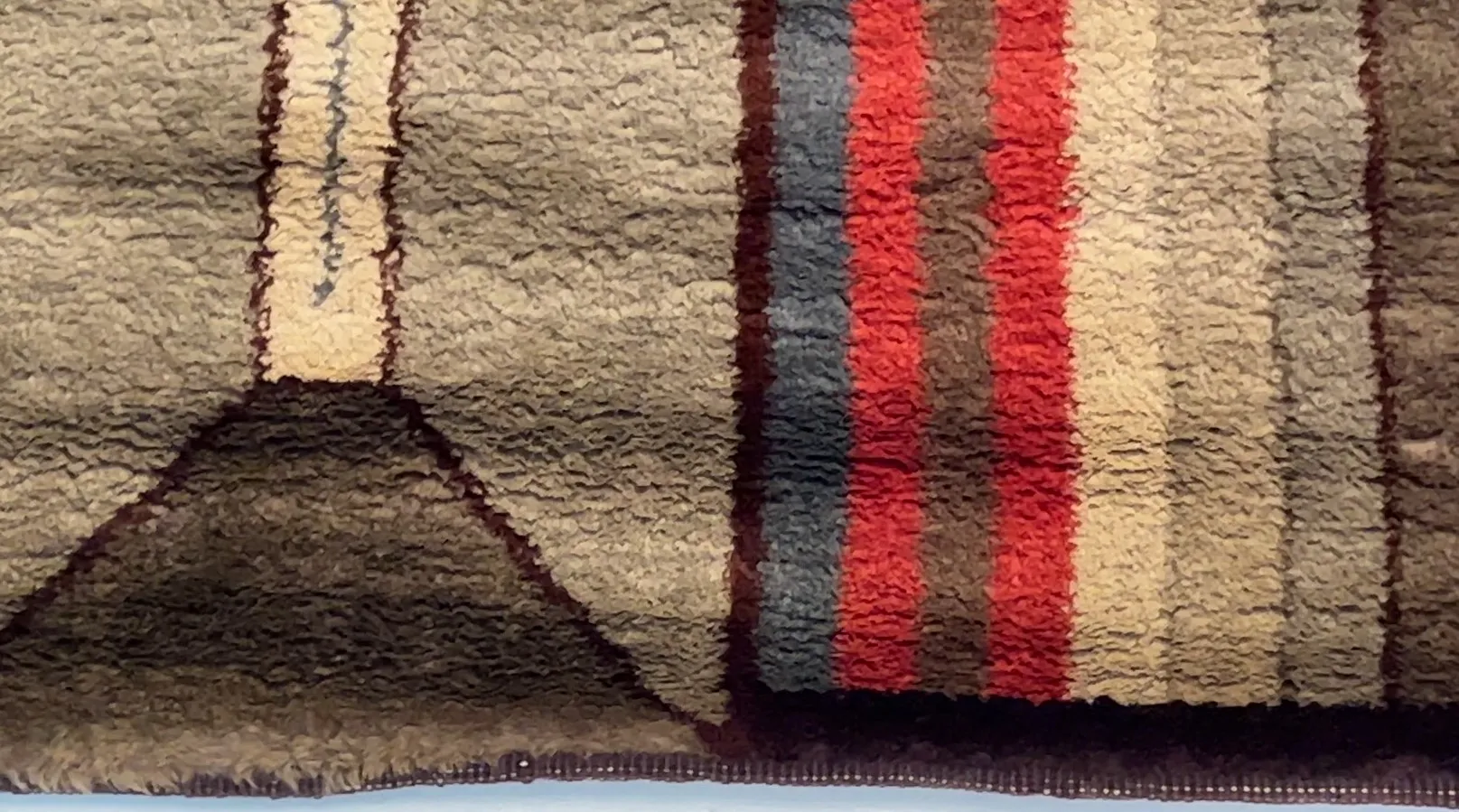 tapis ancien avec des rayures dans des tons terreux et des couleurs vives