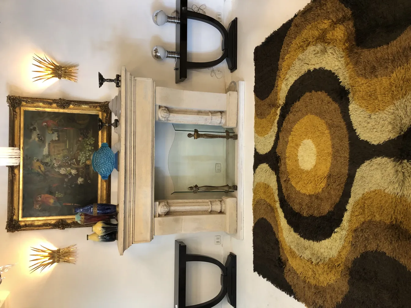 tapis ancien avec design circulaire en couleurs marron et beige, dans un cadre élégant avec des tableaux anciens