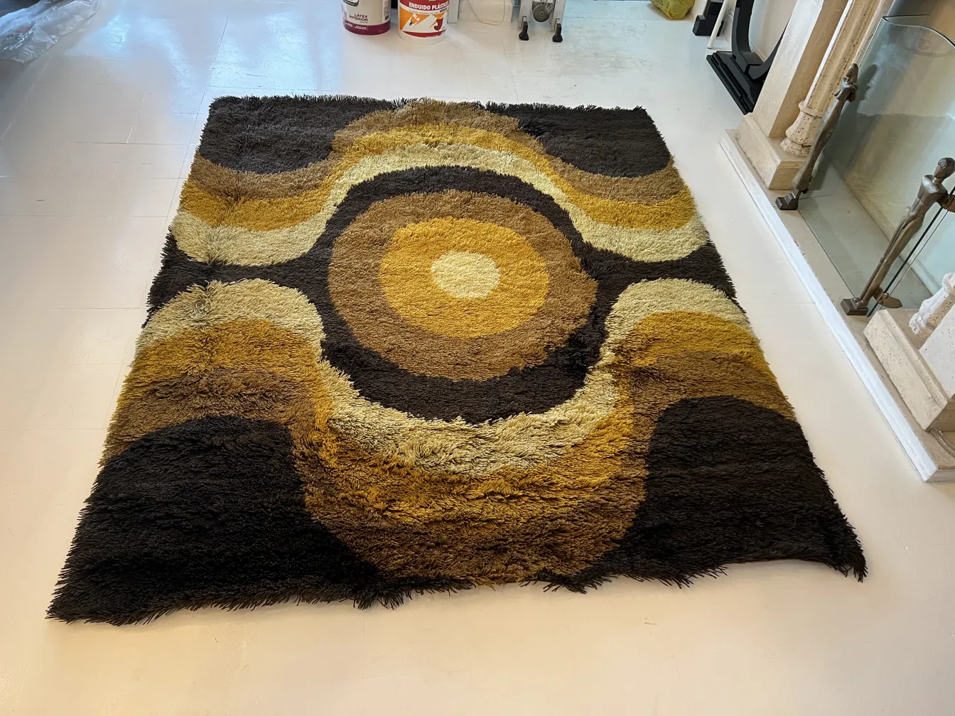 tapis ancien avec un design abstrait dans des tons bruns et jaunes, idéal pour la décoration