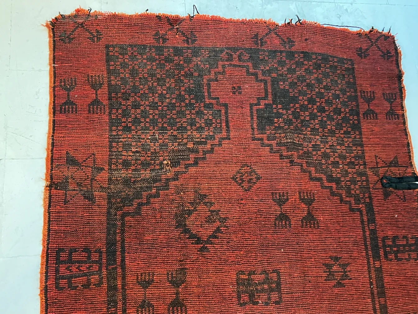 tapis ancien rouge avec motifs noirs