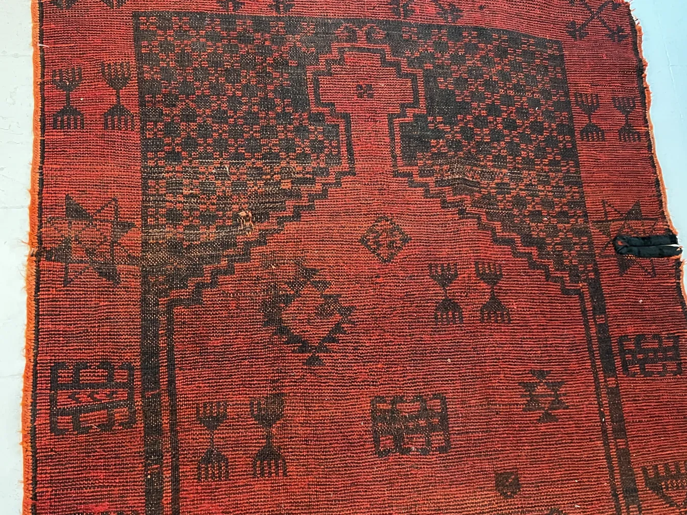 سجاد قديم باللون الأحمر مع نقوش داكنة