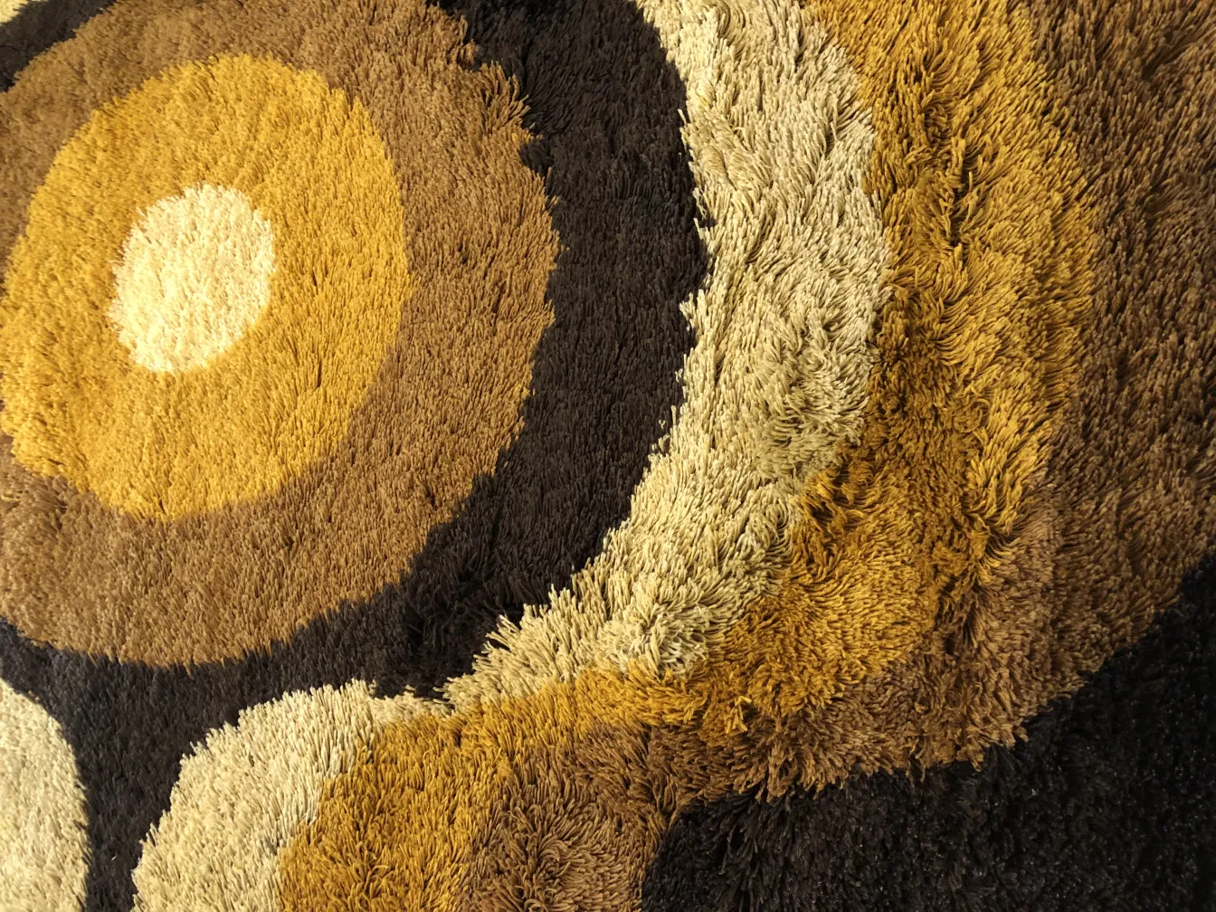 tapis ancien avec des designs géométriques en tons de brun et beige