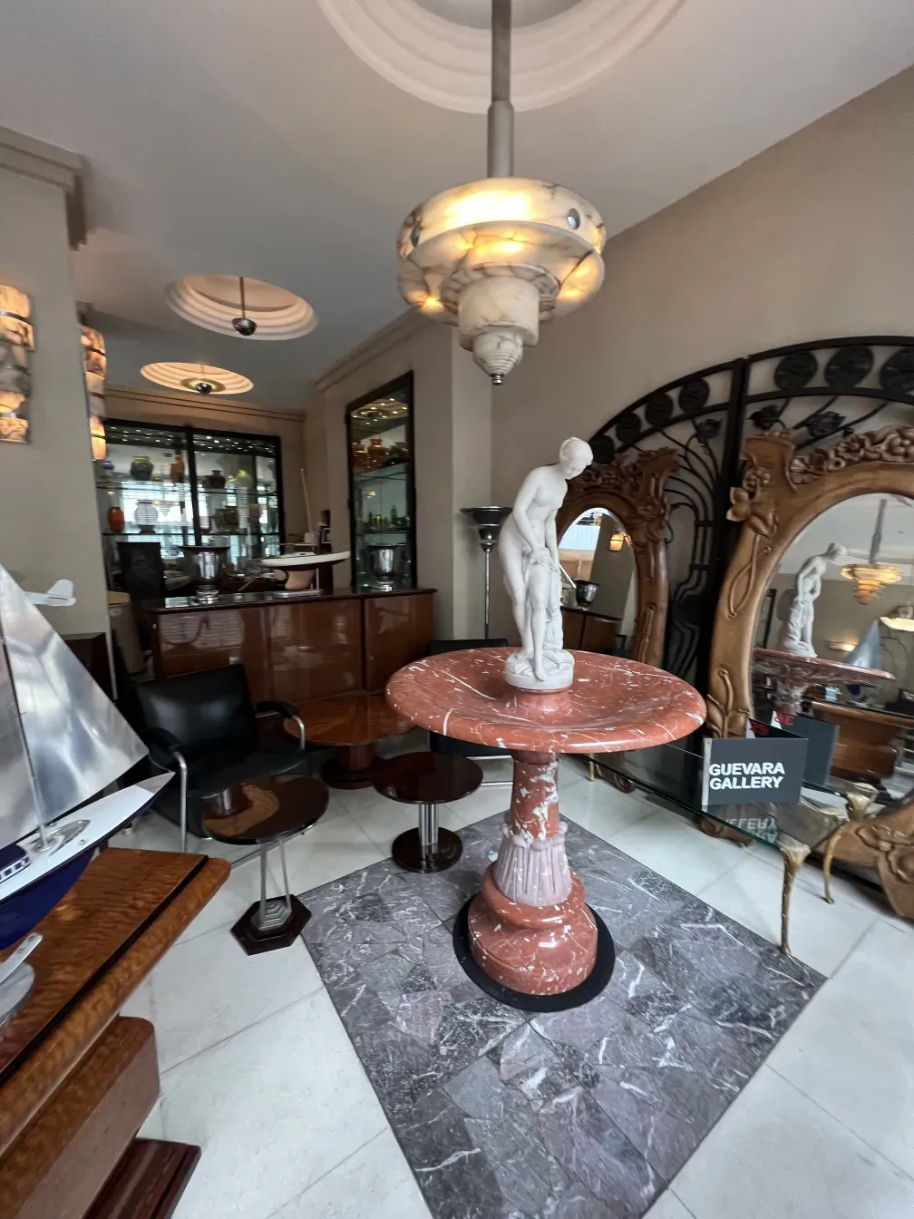 Antique decorative fountain in pink tones within an elegant setting.