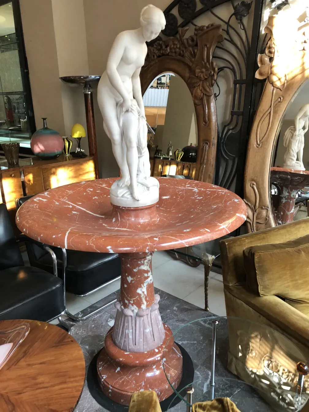 Fonte antiquada elegante com figura feminina em mármore.