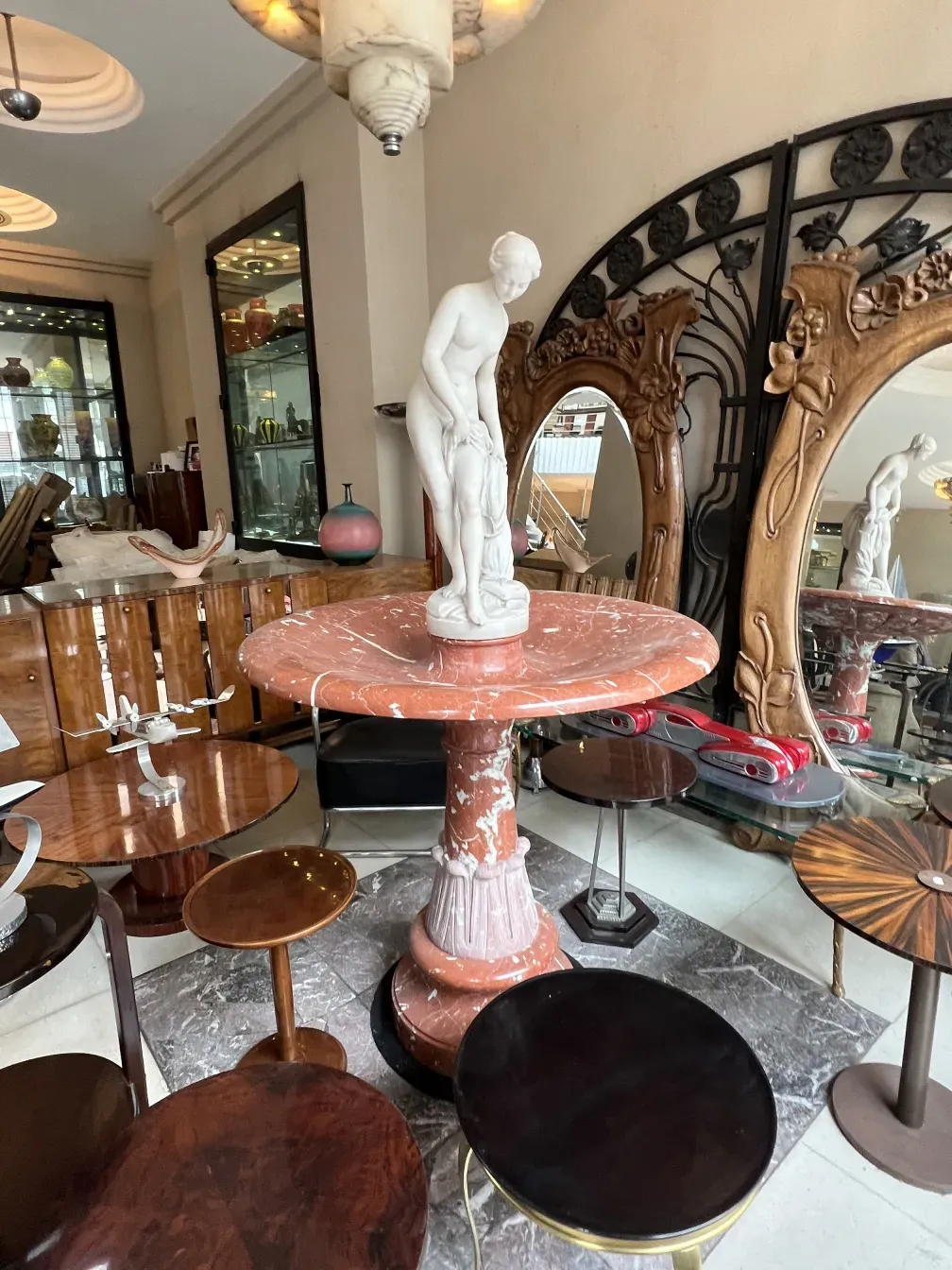 Fonte antiga Art Nouveau com figura clássica em ambiente elegante.