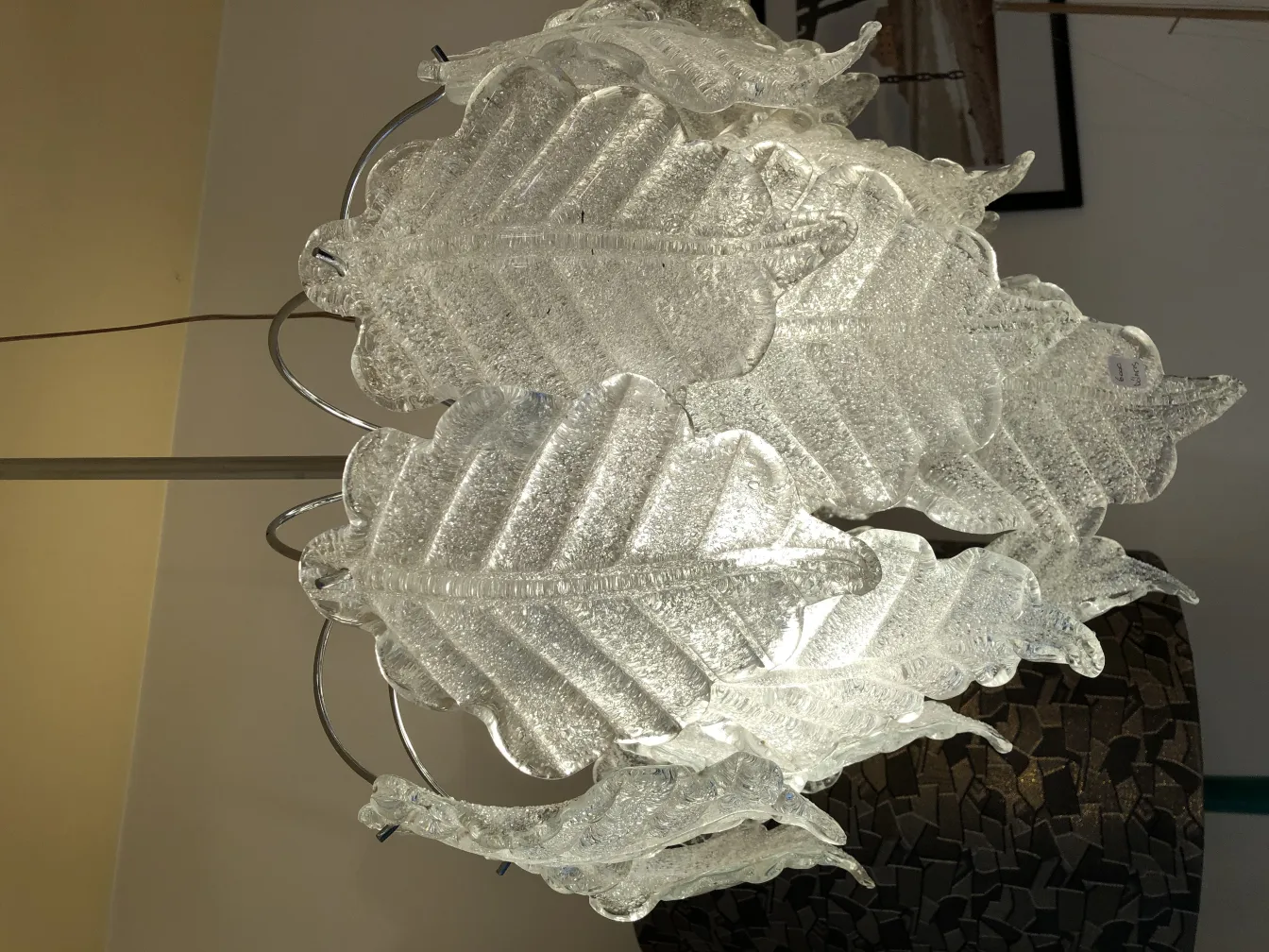 due lampade a sospensione antiche a forma di foglia che illuminano uno spazio