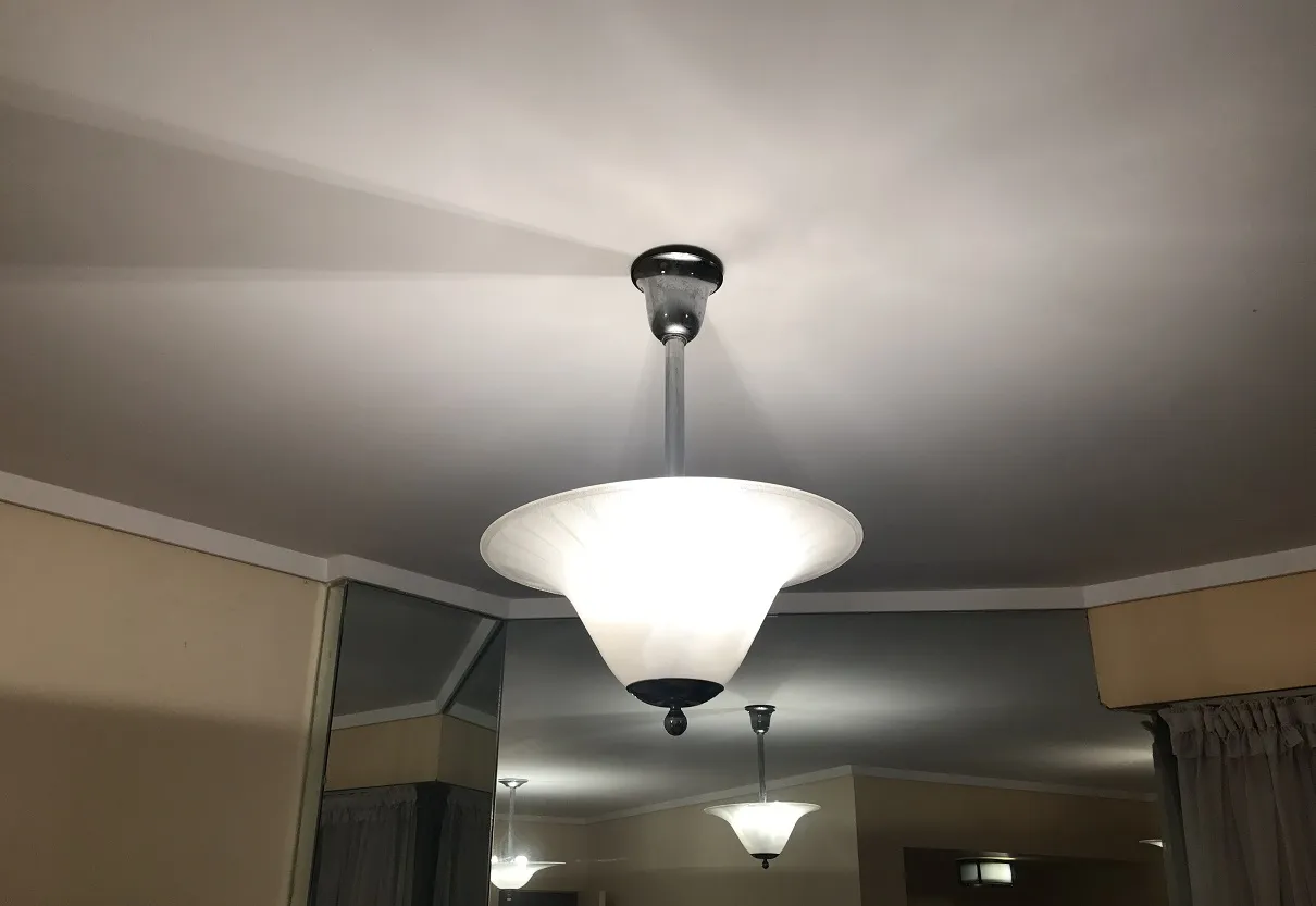 Juego de dos lámparas de techo antiguas suspendidas en un ambiente acogedor, iluminadas suavemente.