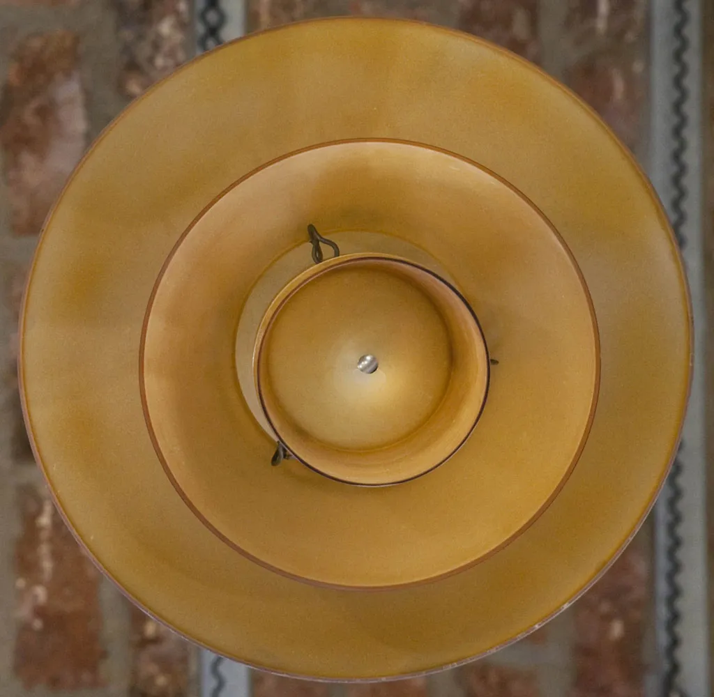 Vue du dessus de deux lustres anciens de couleur jaune, forme distinctive et détails clairs, ambiance chaleureuse.