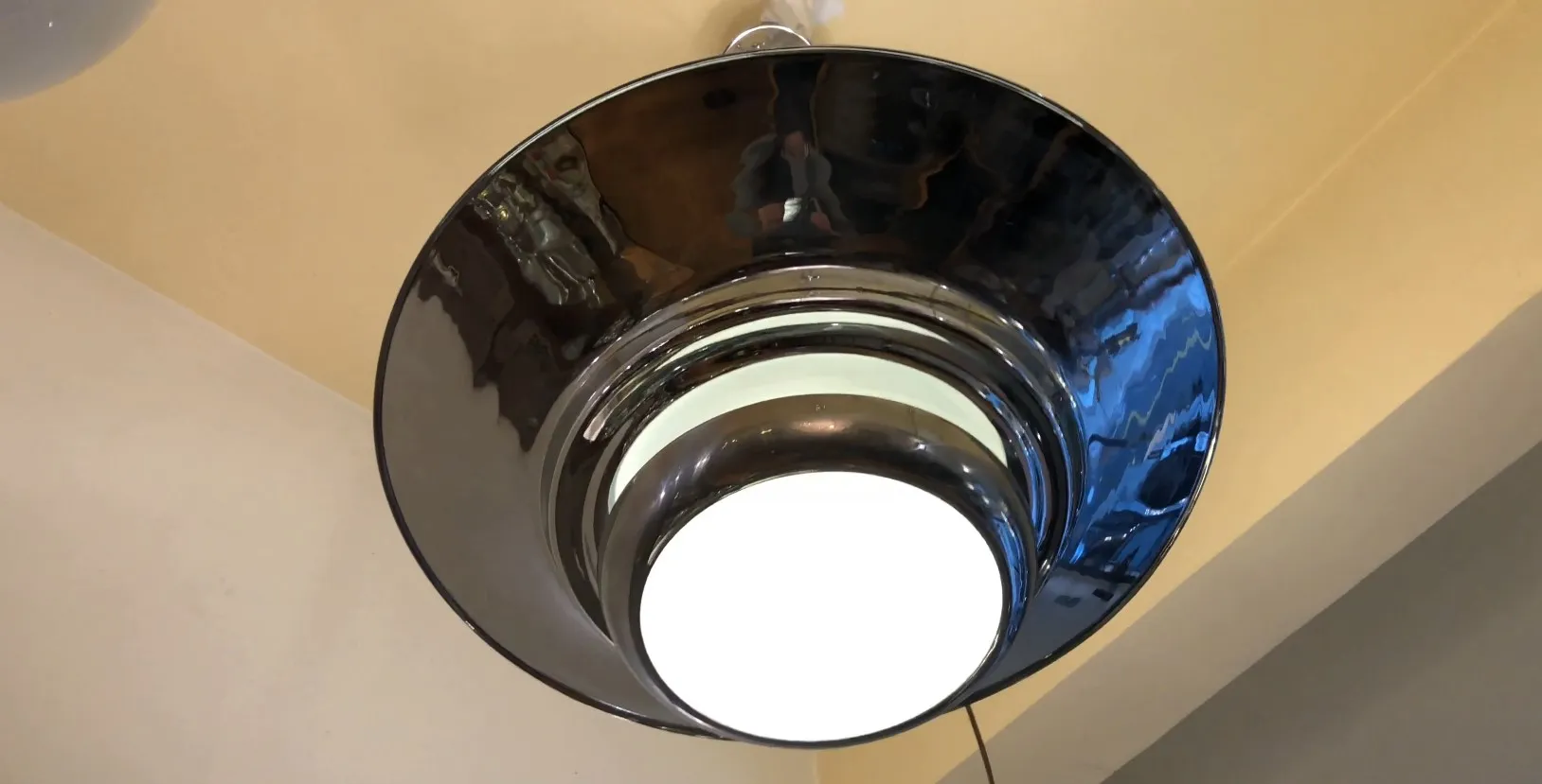 Vista di due lampade a sospensione antiche, dal design elegante, in un ambiente accogliente