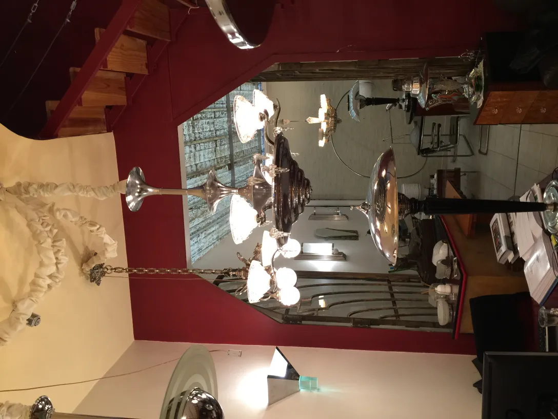 Deux lustres anciens illuminant une pièce avec élégance. Fond coloré et mobilier classique.