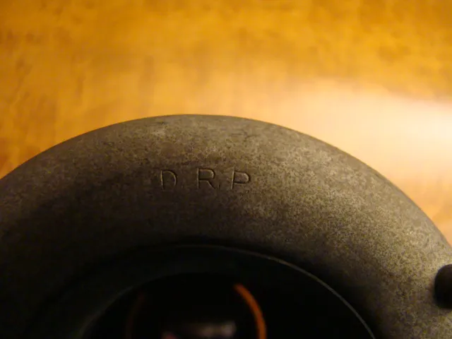 Vue rapprochée de deux lustres anciens au design hawaïen sur un fond chaleureux.