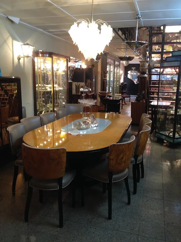 2 lustres anciens suspendus au-dessus d'une table ovale dans un cadre bien décoré