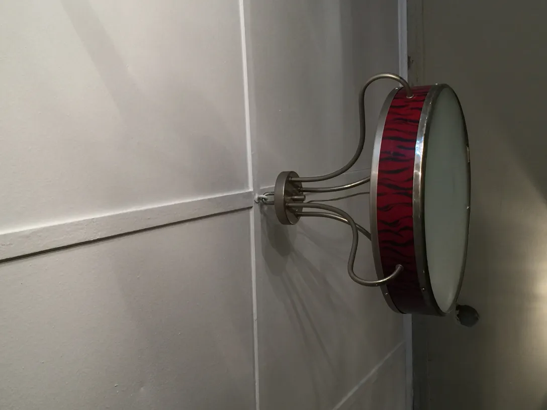 Vue latérale de deux lustres anciens avec un design coloré et vibrant, fixés au mur.