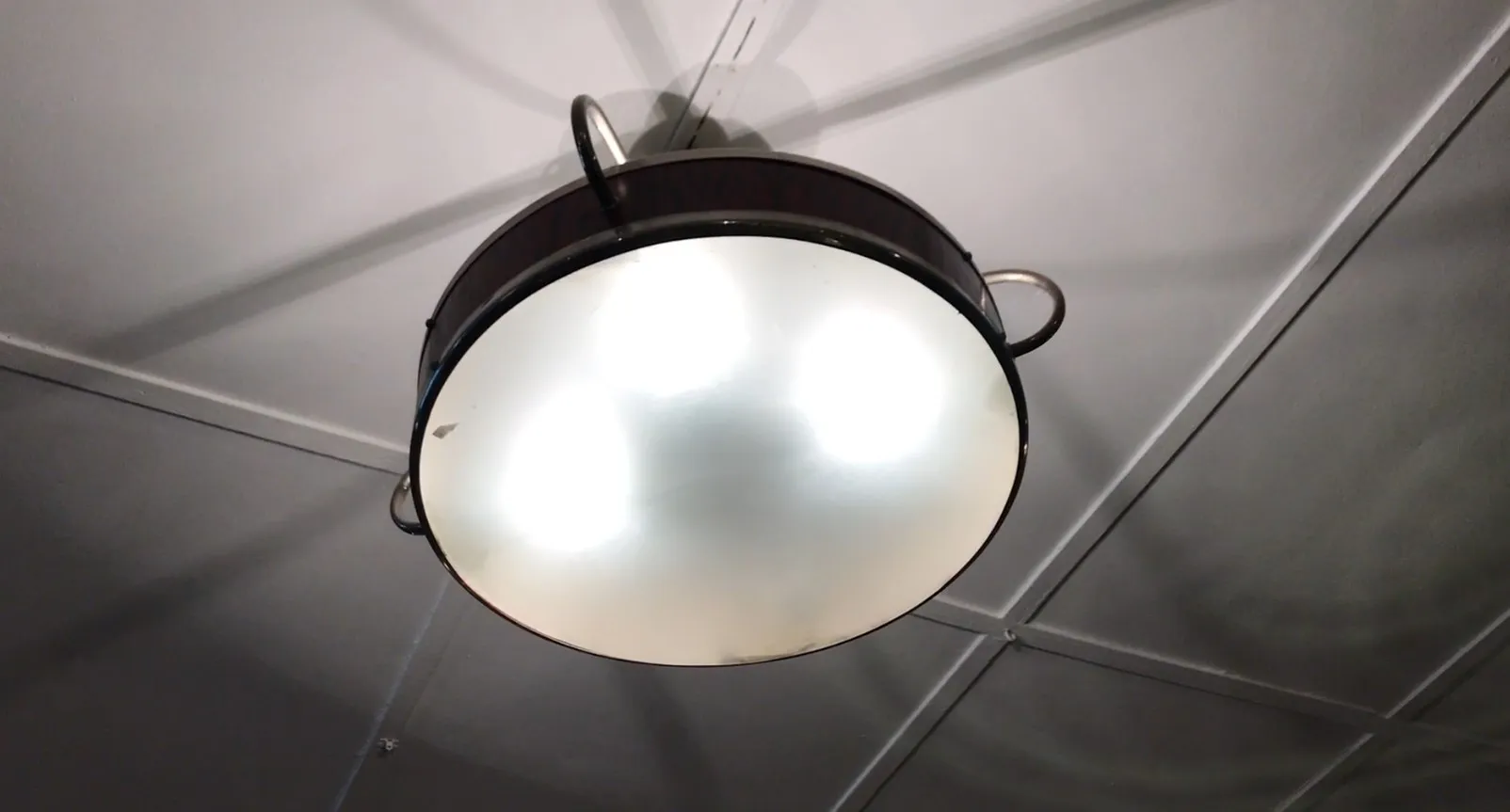 Due lampade a sospensione antiche con design circolare, abbellendo uno spazio moderno.