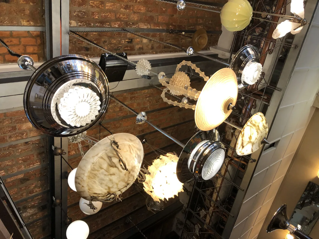 Due lampade a sospensione antiche con diverse forme e stili in un ambiente decorativo.