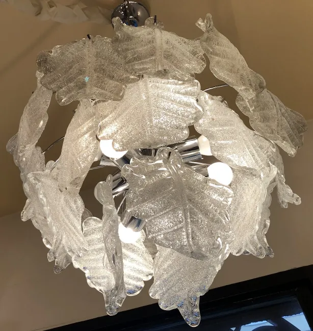 Duas lampadas de teto em forma de folhas iluminando um ambiente acolhedor antigo.