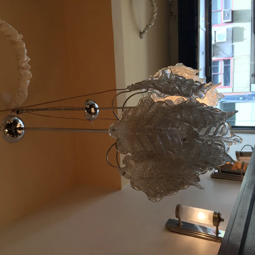 dos lámparas de techo antiguas con forma de hojas y detalles brillantes, colgando en una habitación iluminada